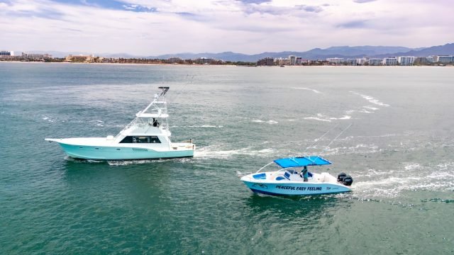 Los barcos Steel n Time y Peaceful Easy Feeling de Ol' Salty's Ranch navegando frente a la costa de Nuevo Vallarta, con la Sierra Madre al fondo