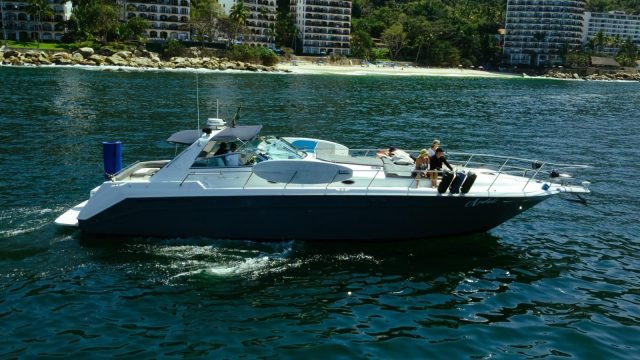 Yate Sea Ray 50 Sundancer con un grupo a bordo navegando frente a la costa sur de Puerto Vallarta, ejemplo de renta de yates para celebrar en la Bahía de Banderas
