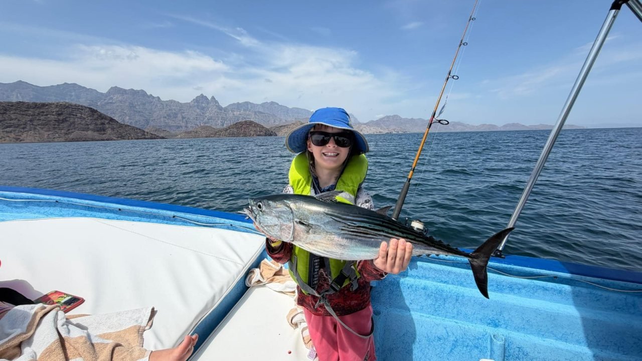 Pescador con un jurel en la proa de la panga Loreto Star frente a Isla del Carmen